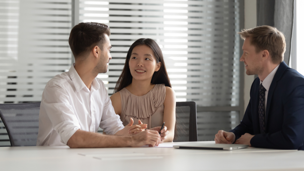A couple consults a property agent to understand their legal rights before buying property in Thailand.