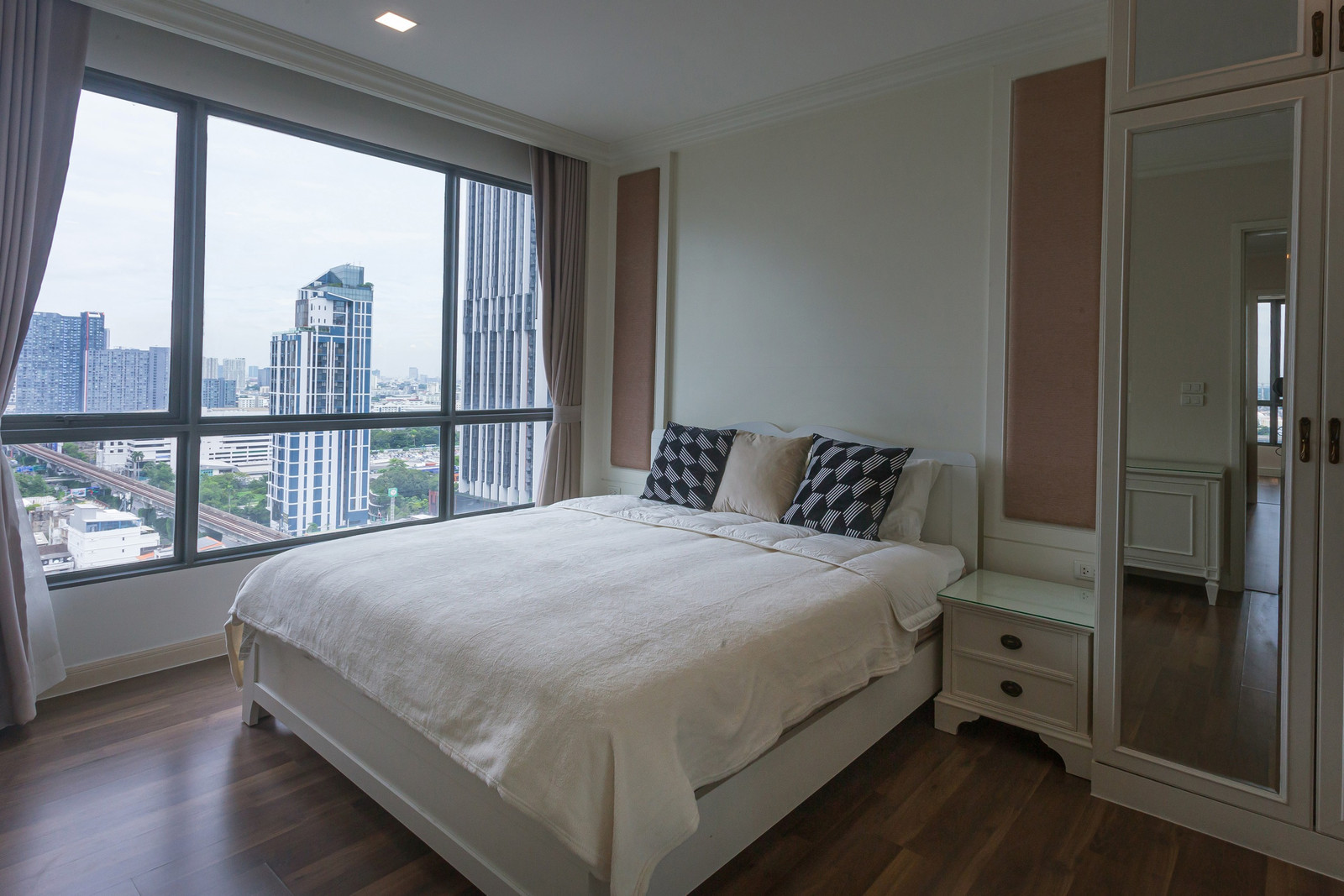 The Room Sukhumvit 62: High-floor corner unit with open city and Chao Phraya River bend views from the balcony and both bedrooms.